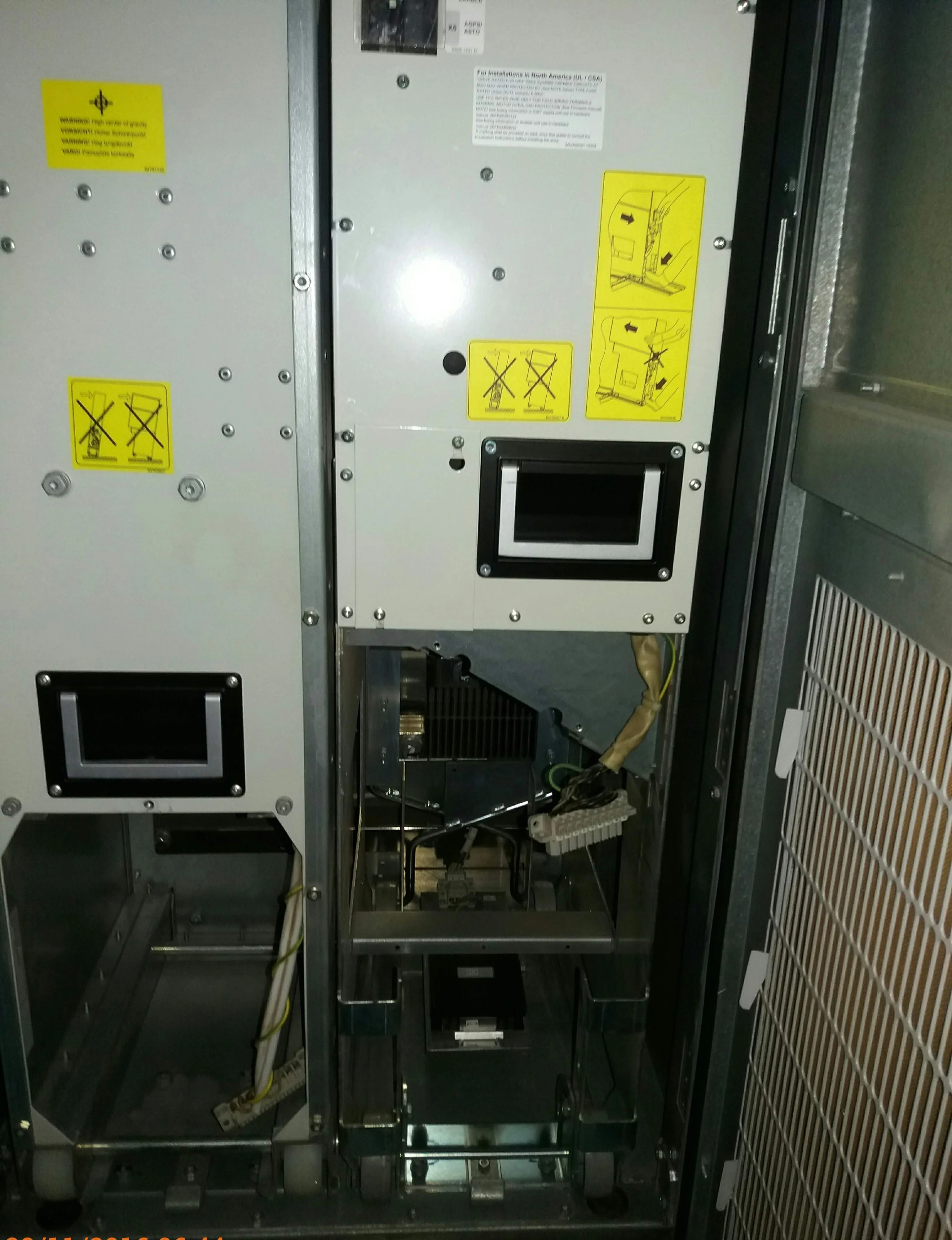 Utility-scale central solar inverter cabinet with the front door open during cooling fan maintenance, showing the lower fan section, and right-side air vent
