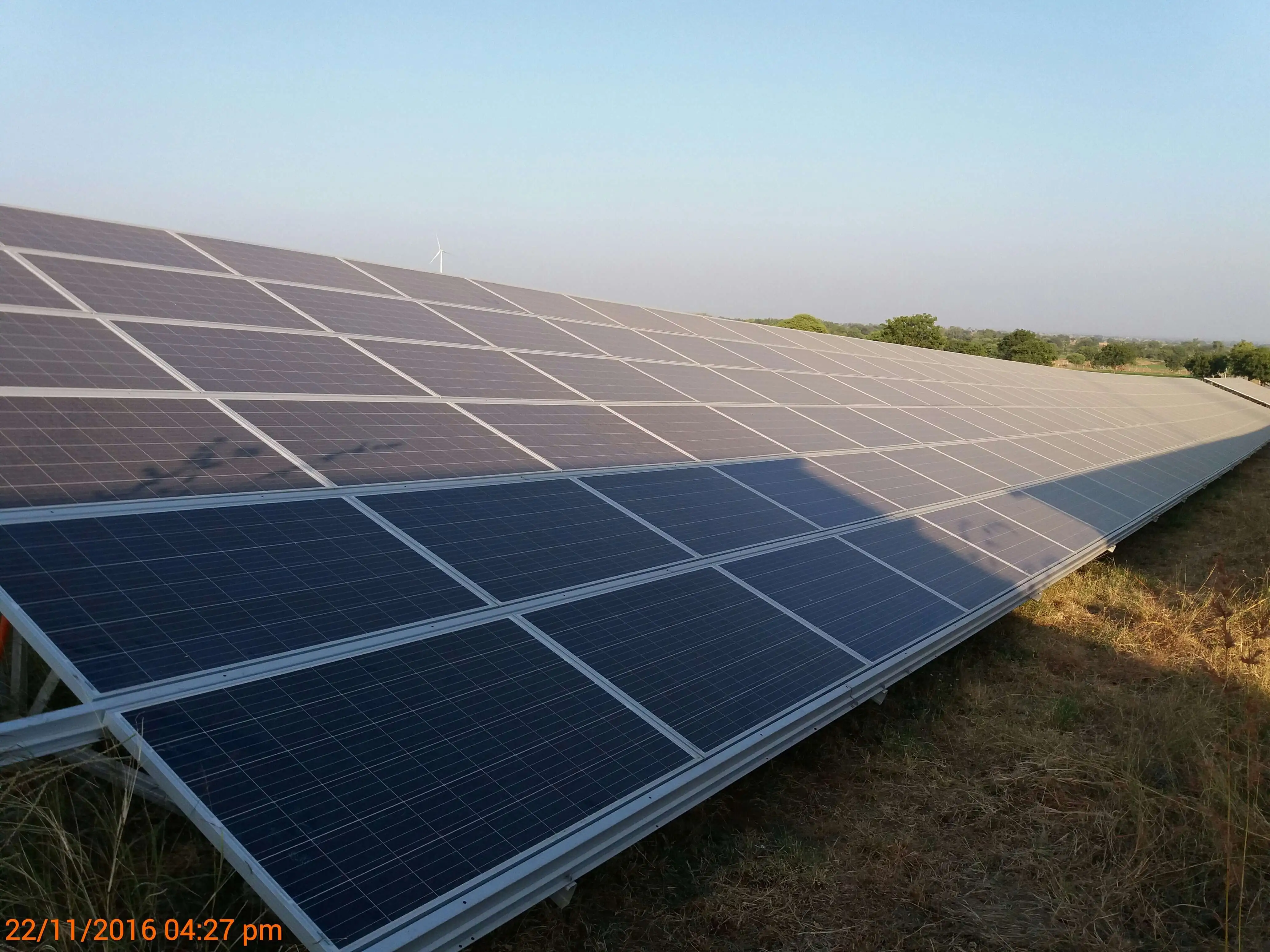 Frontal view of a ground-mounted PV array showing the exact cell-row boundary of inter-row shadow shading at module level on 22 November 2016